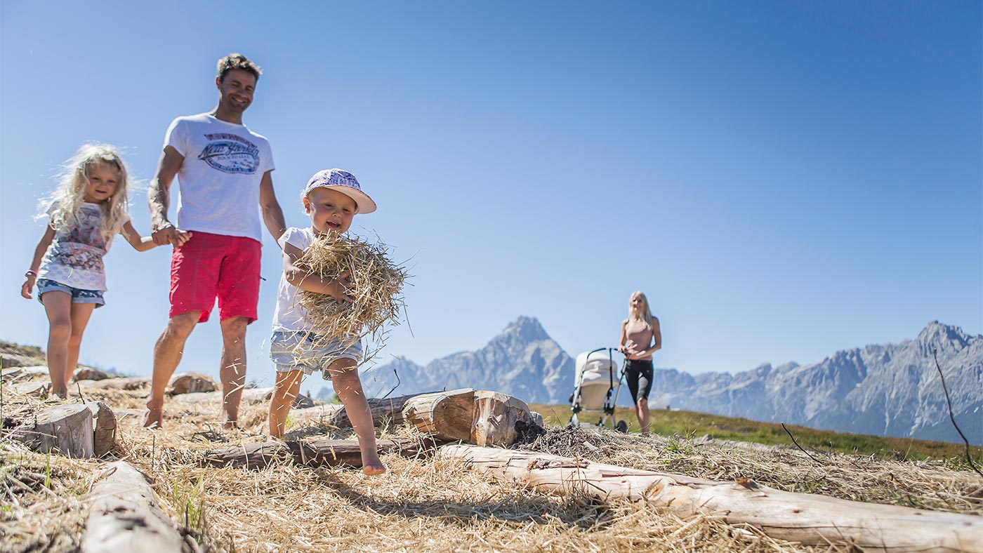 A young family gathering hay in San Candido