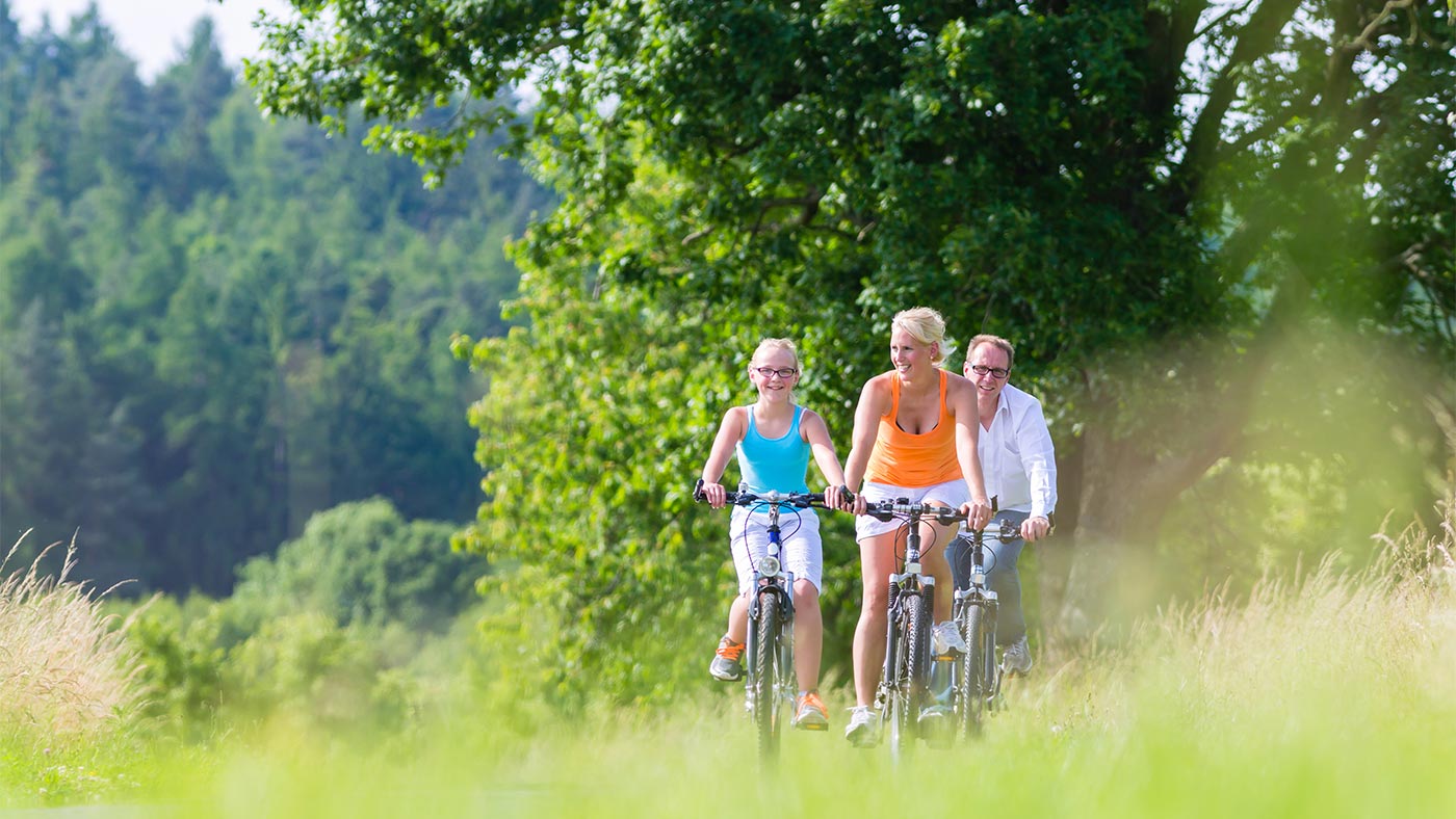 Una famiglia durante un giro in mountain bike nella natura intorno a San Candido