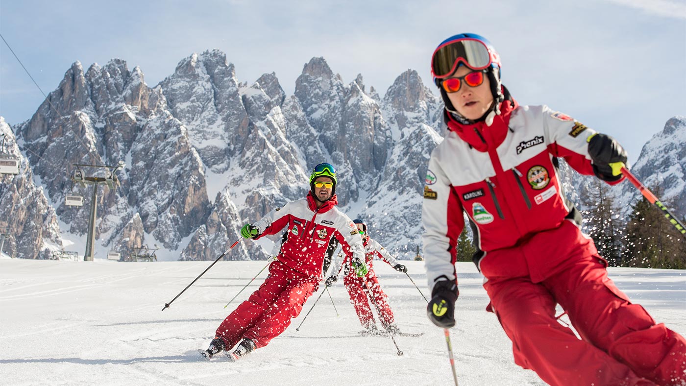 Some skiers on a descent in San Candido in winter